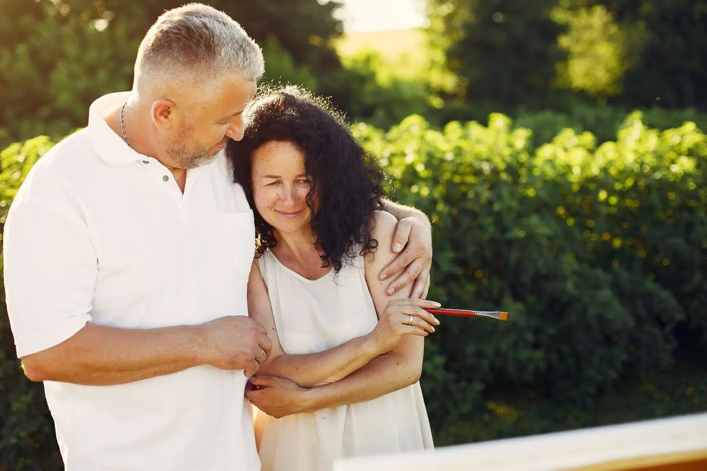 A beautiful adult couple sketching in a summer field.